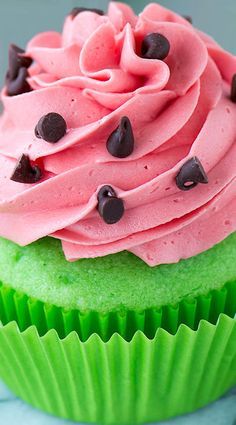 a cupcake with pink frosting and chocolate chips