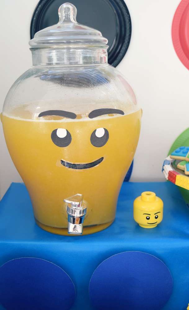 there is a yellow drink dispenser on top of a blue table with legos around it