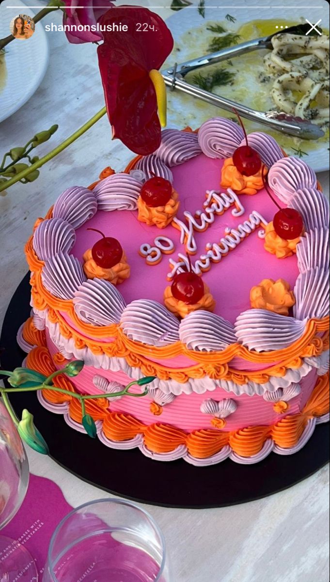 a pink and orange cake sitting on top of a table