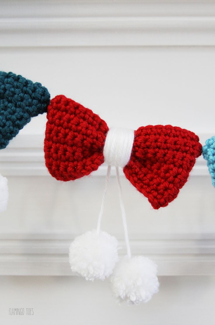 crocheted bow with pom poms hanging from the ceiling