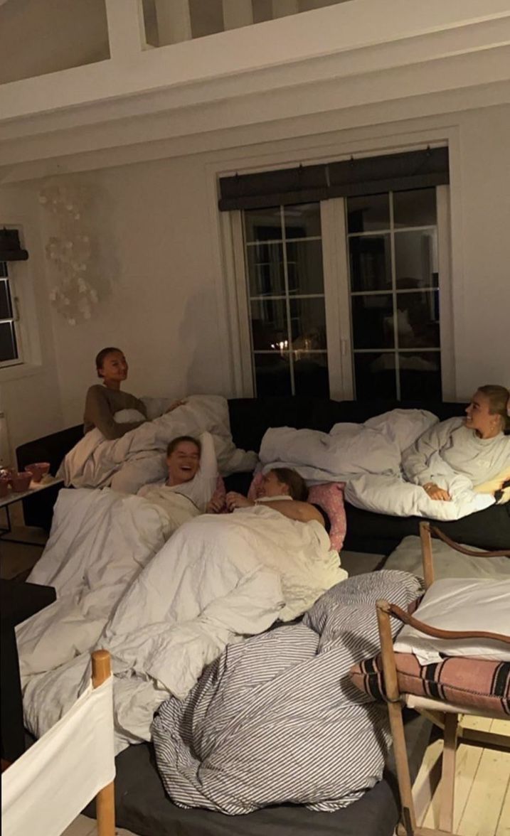 a group of people laying in bed with blankets on them