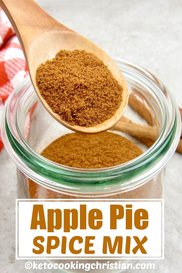 an apple pie spice mix in a glass jar with a wooden spoon and cinnamon sticks