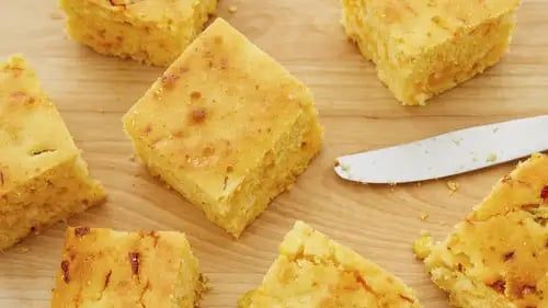 several pieces of cake sitting on top of a wooden cutting board next to a knife