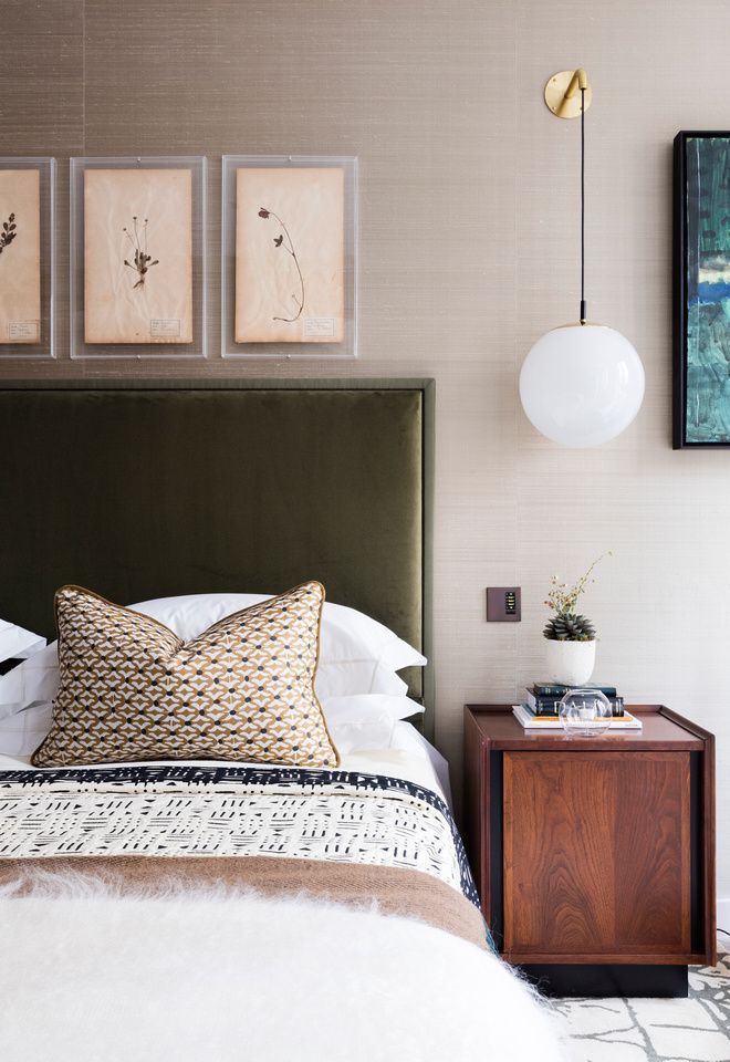 a bed with white sheets and pillows next to two pictures on the wall above it