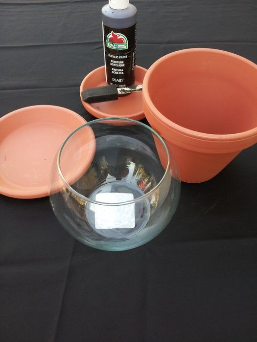 there are two bowls and one bowl on top of the table with black cloth behind it