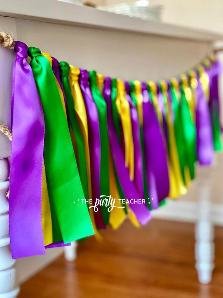 colorful streamers are hanging from the side of a white table with wood flooring