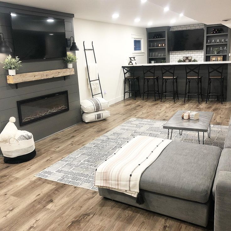 a living room filled with furniture and a flat screen tv mounted on the wall above a fireplace