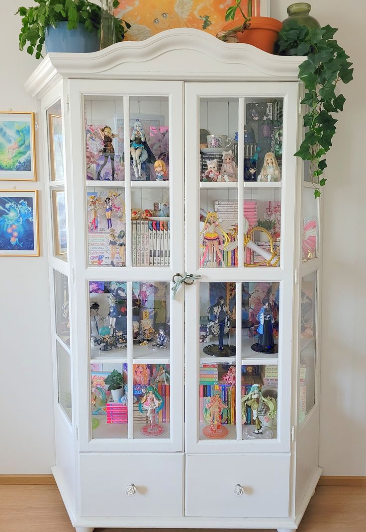 a white china cabinet filled with lots of toys