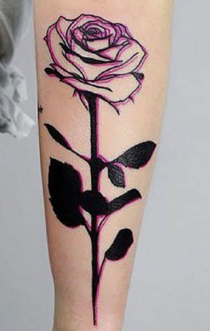 a black and pink rose tattoo on the arm