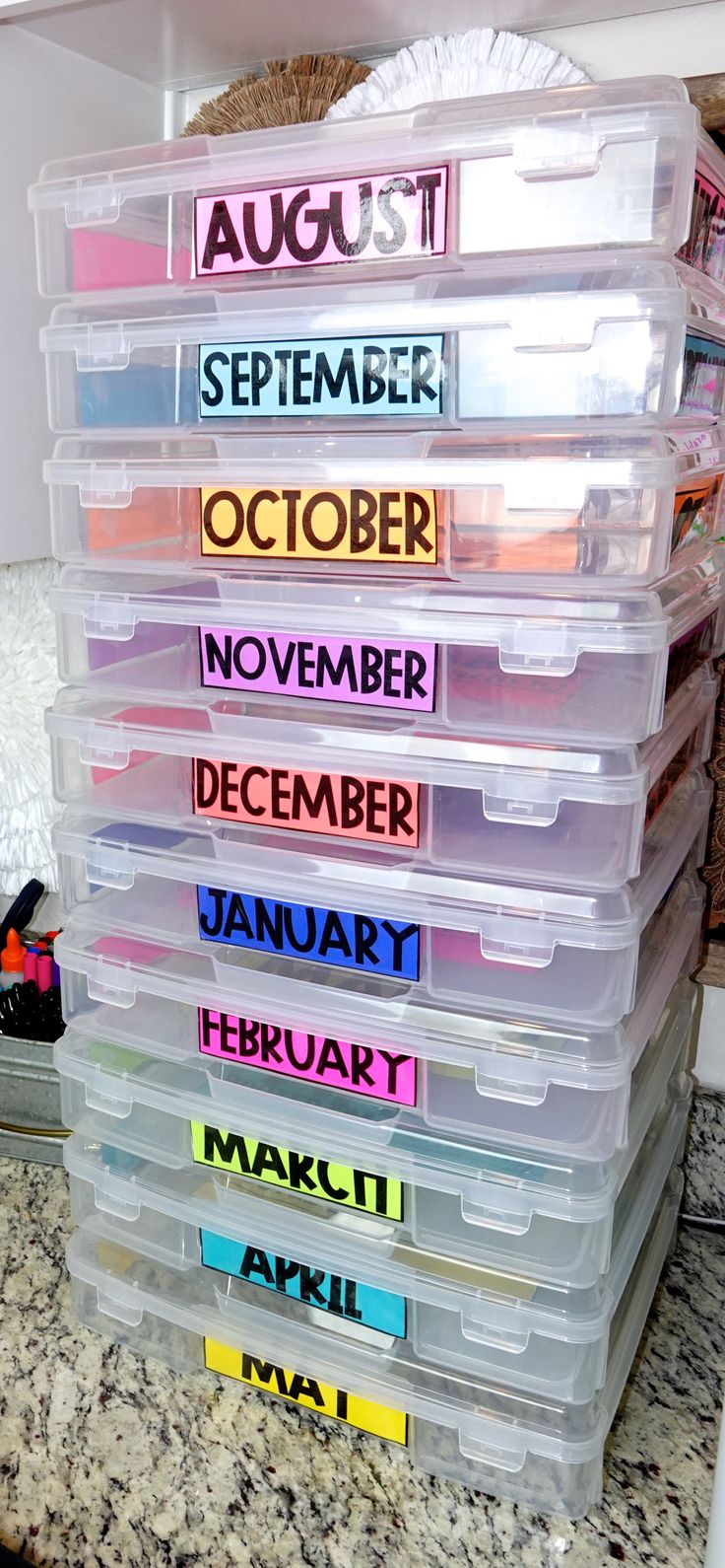 a stack of plastic containers filled with different colored labels