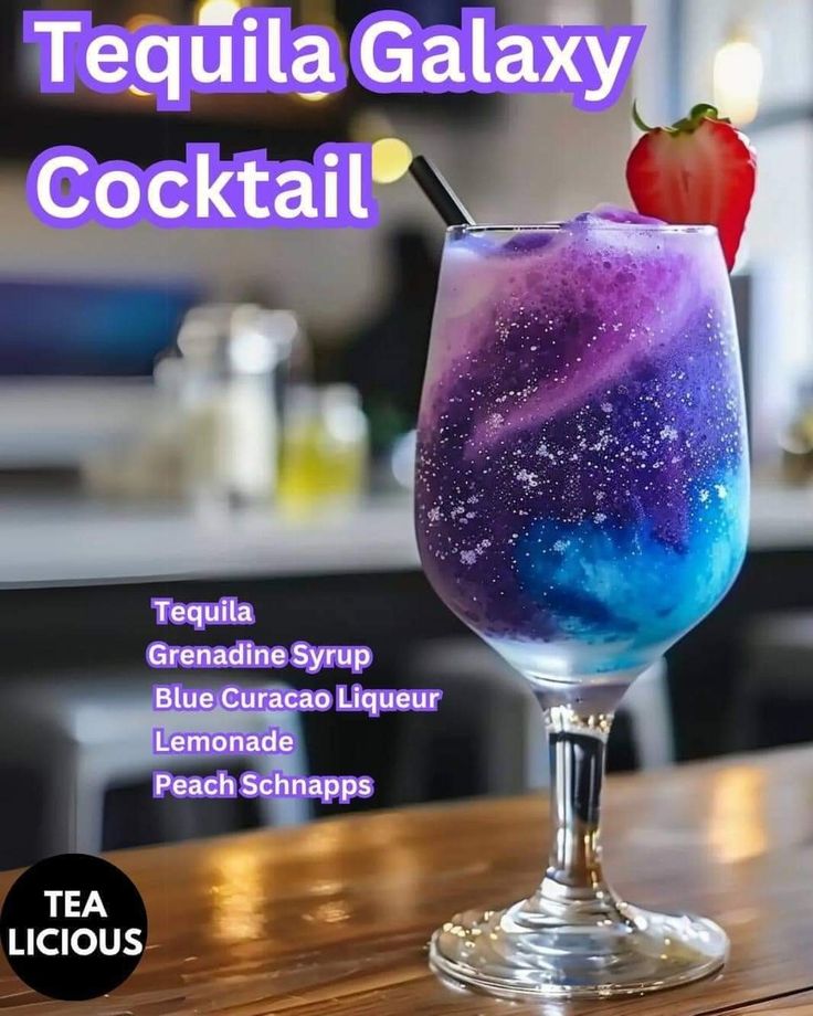 a purple and blue drink sitting on top of a wooden table next to a strawberry