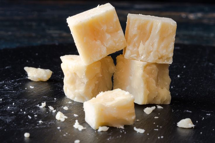 several pieces of cheese sitting on top of a black plate