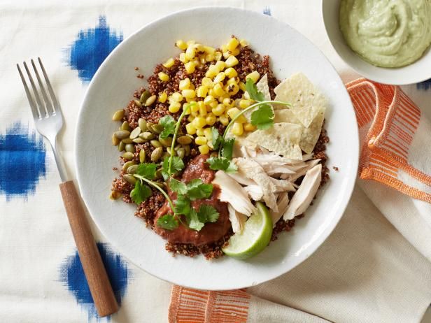 a white plate topped with meat and veggies next to a bowl of guacamole