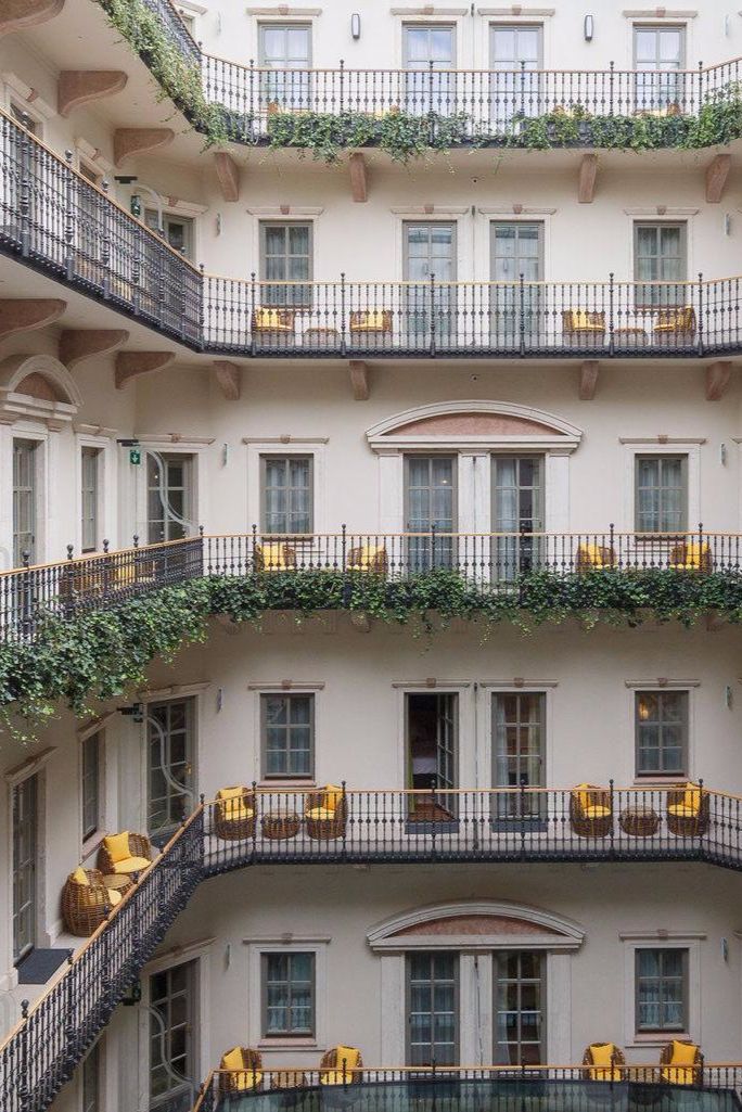 an apartment building with balconies and plants growing on the balconies above