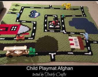 a child's play mat with cars, trucks and houses on it is shown