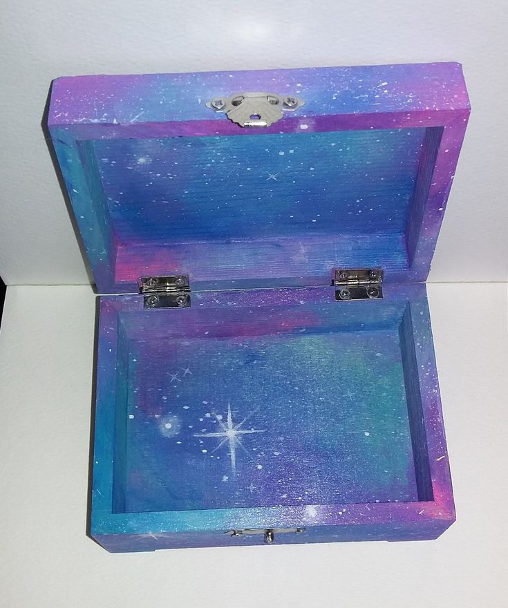 an open purple and blue box sitting on top of a white table with stars in the sky