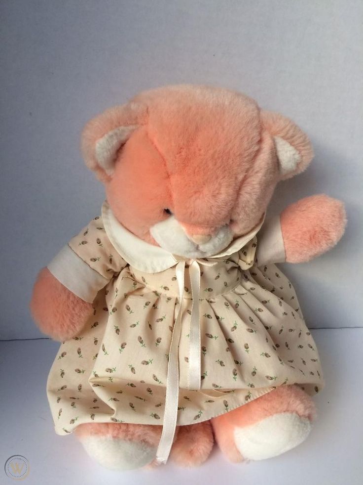 a pink teddy bear dressed in a dress