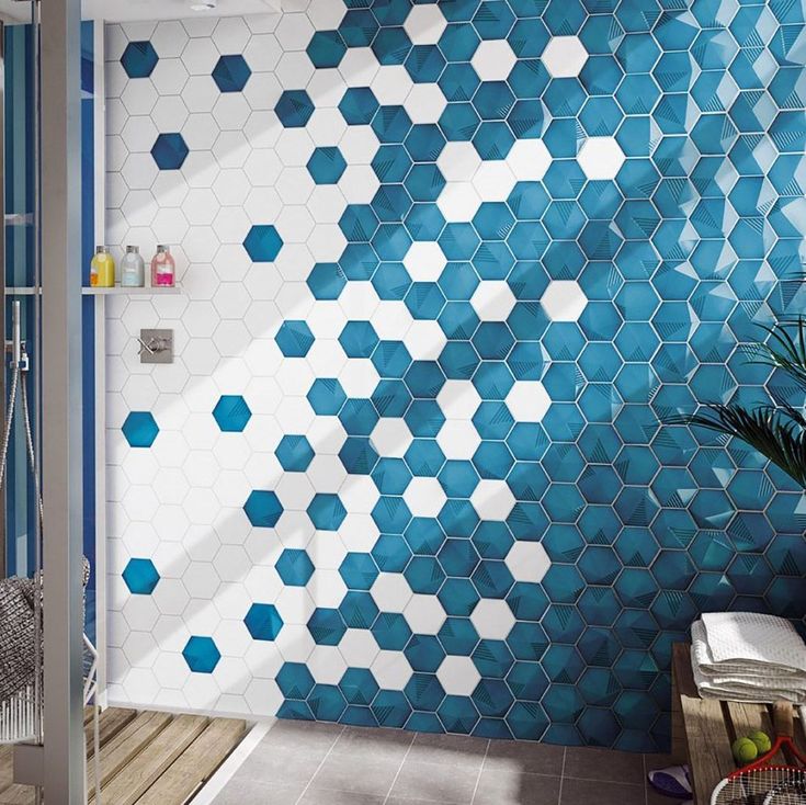 a bathroom with blue and white tiles on the wall, shower stall and bathtub