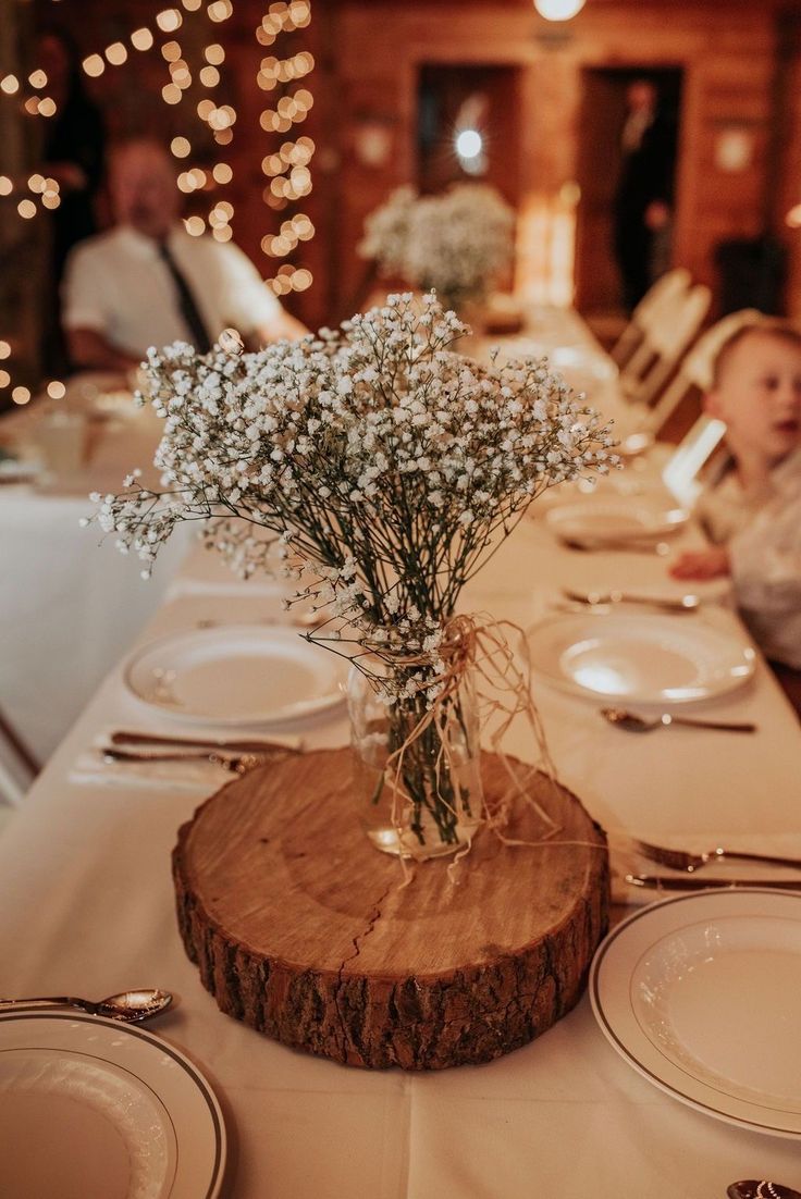 there is a vase with baby's breath in it on top of the table