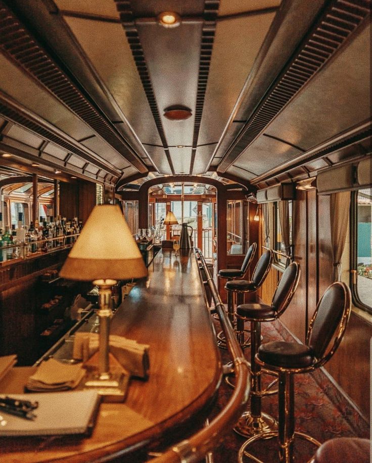 the inside of a bar on a train with lots of chairs and tables in it