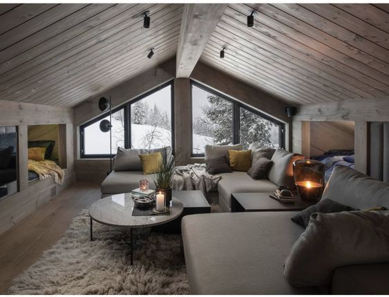 a living room filled with lots of furniture next to a large window covered in snow