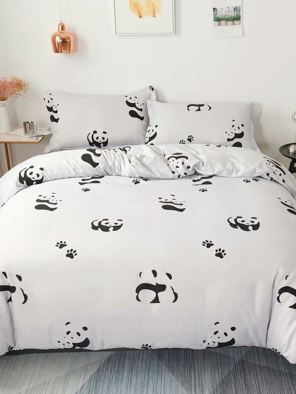 a bed with panda bears on it in a room next to a table and pictures