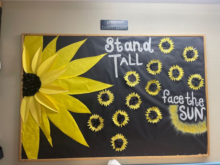 a bulletin board with sunflowers on it and words that read stand tall face the sun