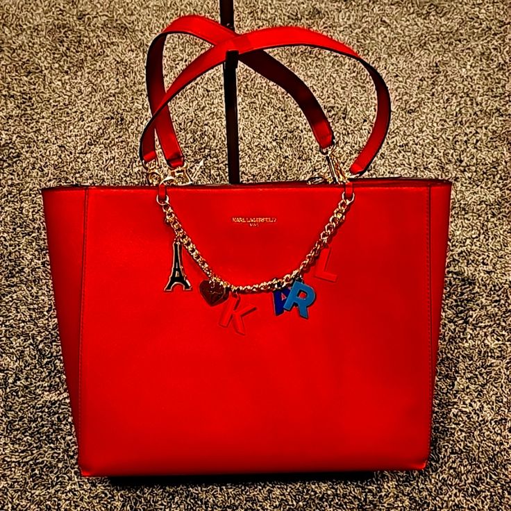 Bright Red New Karl Tote Bag With Chain Decoration And Gold Hardware Red Bags With Chain Strap For Travel, Red Travel Bag With Chain Strap, Red Shoulder Bag With Detachable Handle, Red Evening Bag With Chain, Affordable Red Bags With Gold-tone Hardware, Red Chain Shoulder Bag Rectangular, Luxury Red Bag With Chain Detail, Cheap Red Shoulder Bag With Gold-tone Hardware, Red Handheld Bags With Gold-tone Hardware