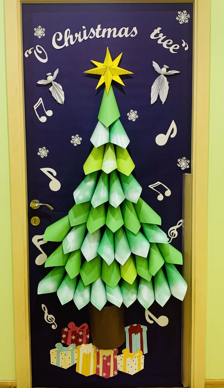 a christmas tree made out of origami on a door with music notes around it