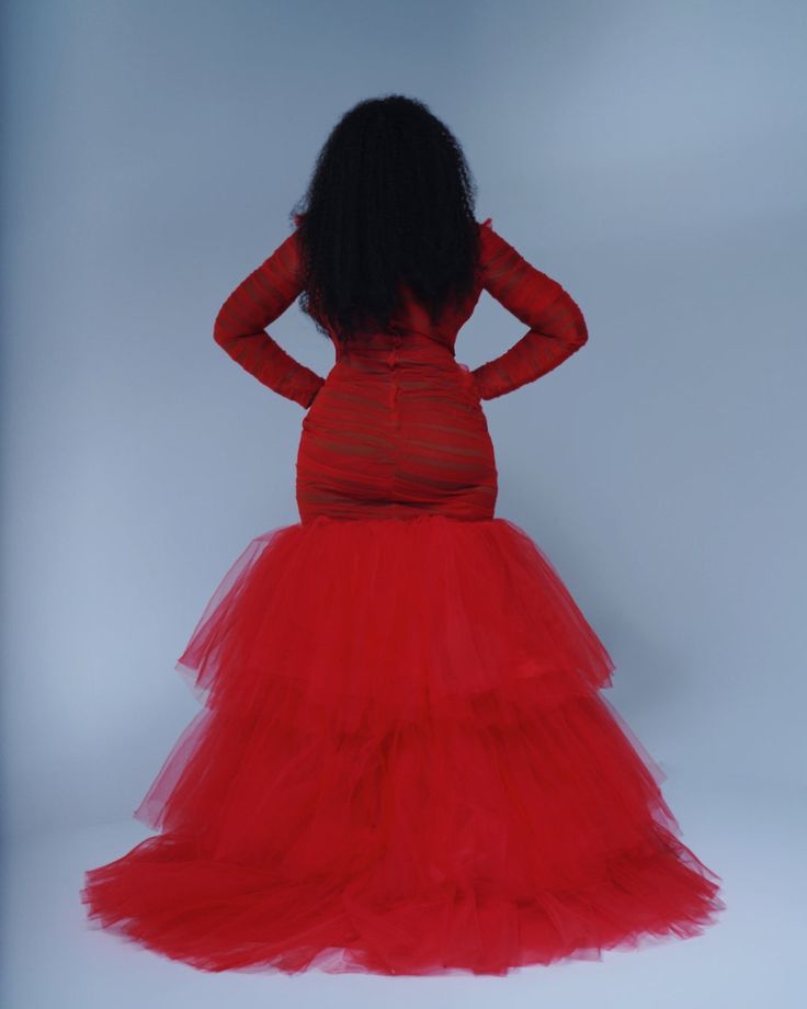 a woman in a red dress with her hands on her hips