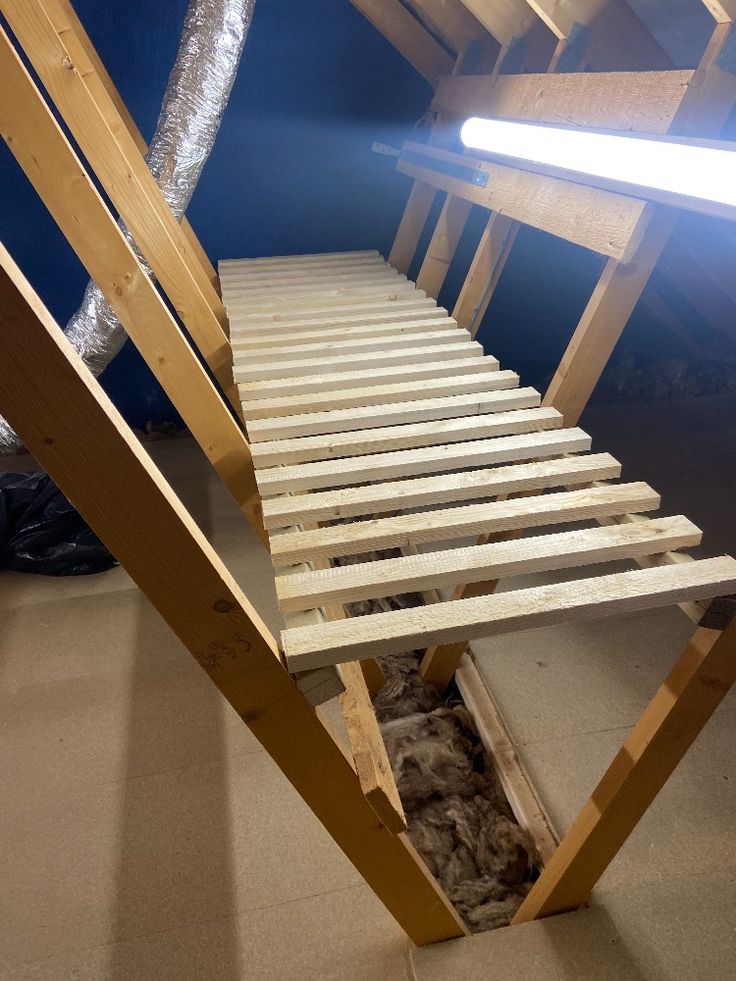 a wooden bed frame in the middle of a room with a light shining on it