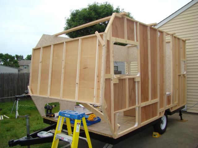 a small trailer is being built on the back of a house with some tools in it