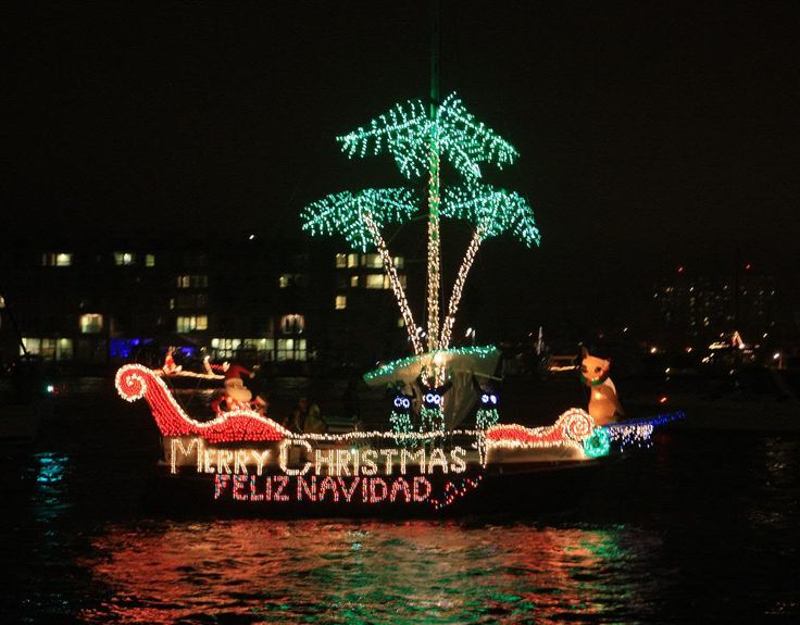 a boat is decorated with christmas lights and palm trees