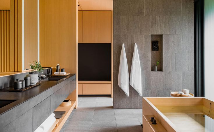 a bathroom with two sinks and towels hanging on the wall