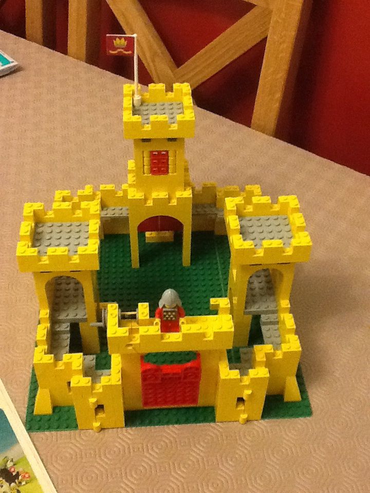 a lego castle sitting on top of a table next to a book and toy mouse