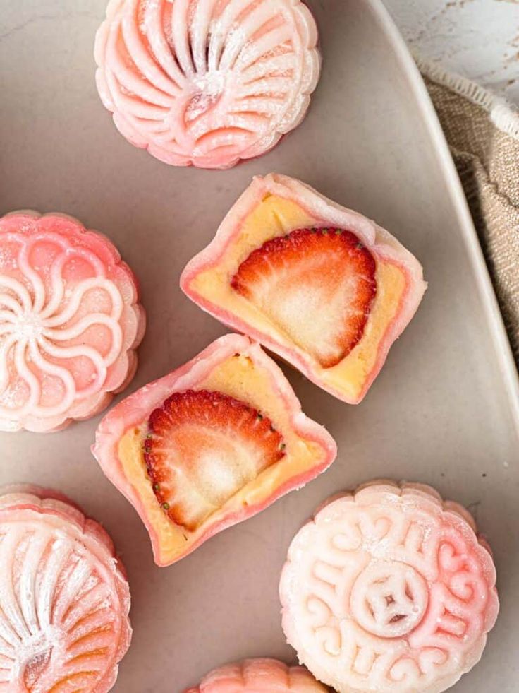 some pink desserts are on a white plate