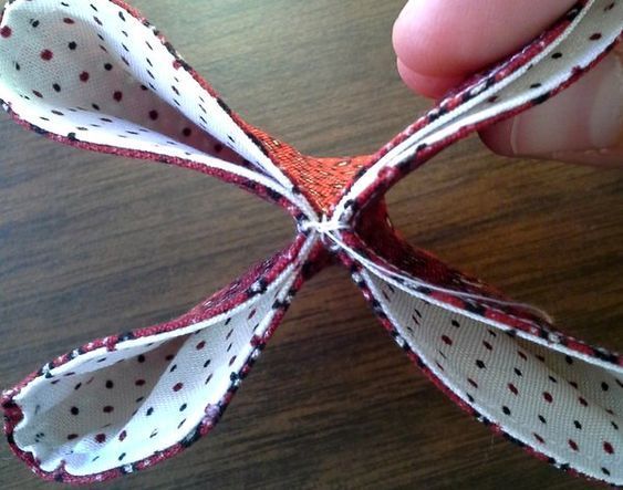 someone is holding an origami piece with red and white polka dots on it