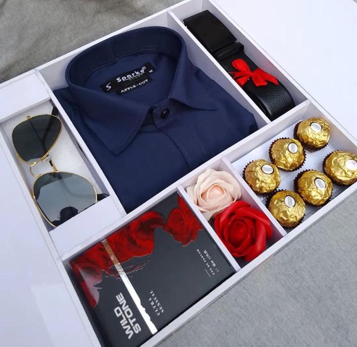 an open box with some items in it on a table next to a pair of sunglasses