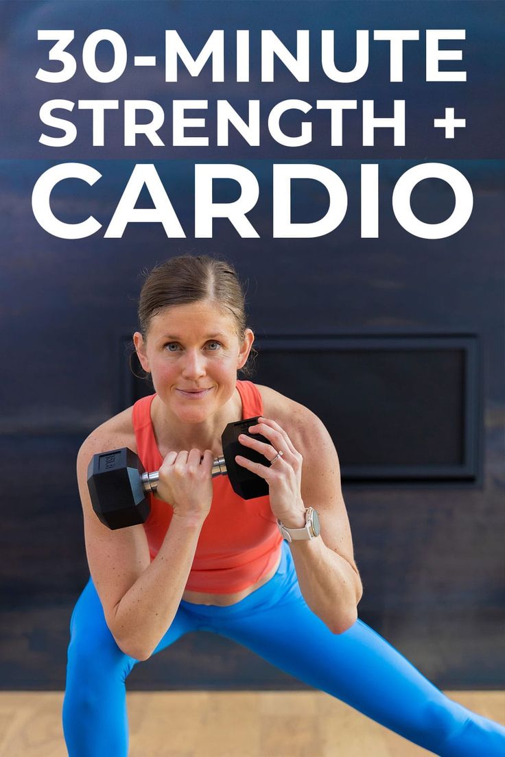 a woman in blue leggings and an orange top is holding a dumbbell