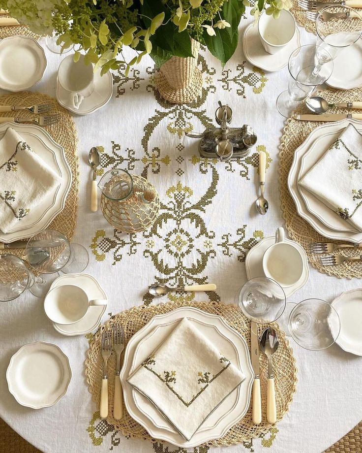 the table is set with white plates and silverware