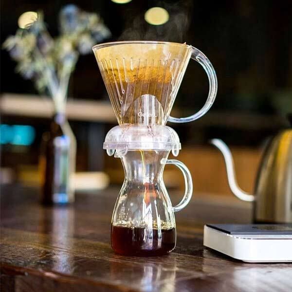 a glass coffee pot sitting on top of a wooden table