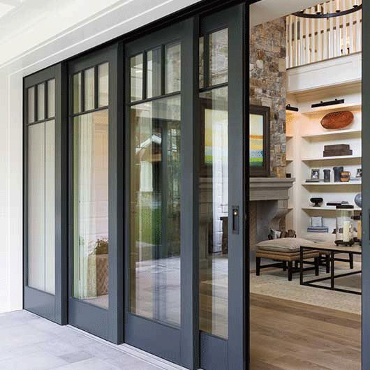 an open door leading to a living room and dining area with glass doors on both sides