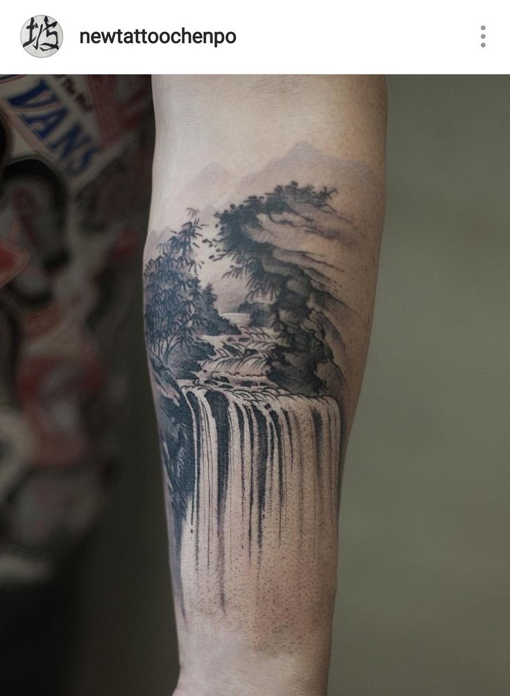 a man's arm with a waterfall tattoo on it