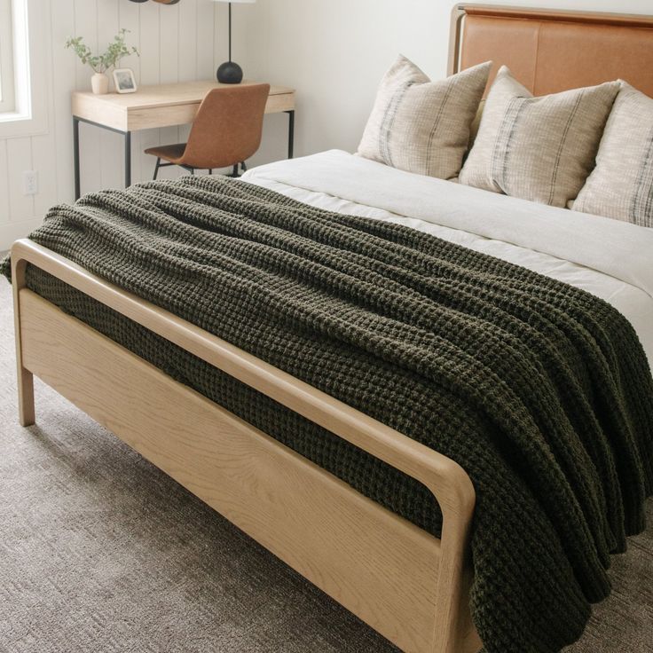 a bed sitting in a bedroom next to a wooden headboard and night stand with two lamps on top of it