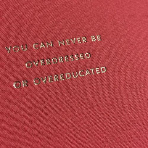 a red book with the words you can never be overdressed or overeducated