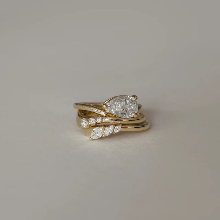 two gold wedding rings with diamonds on each one, set against a plain background for an elegant look