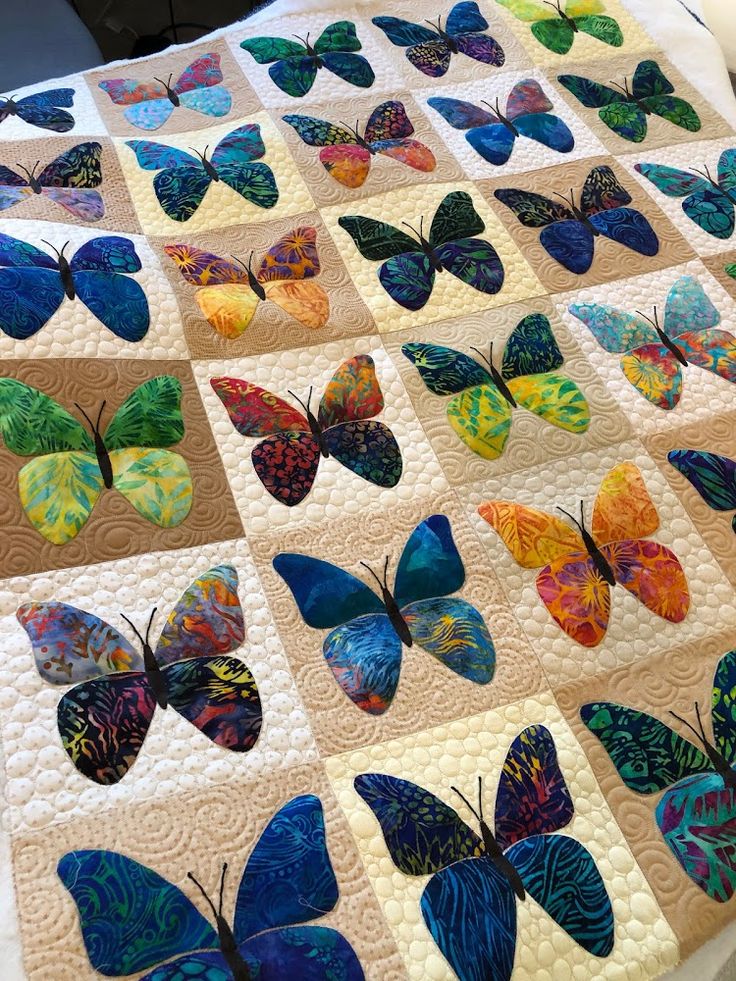 a quilt made with many different colored butterflies on top of each other, including one blue and yellow butterfly