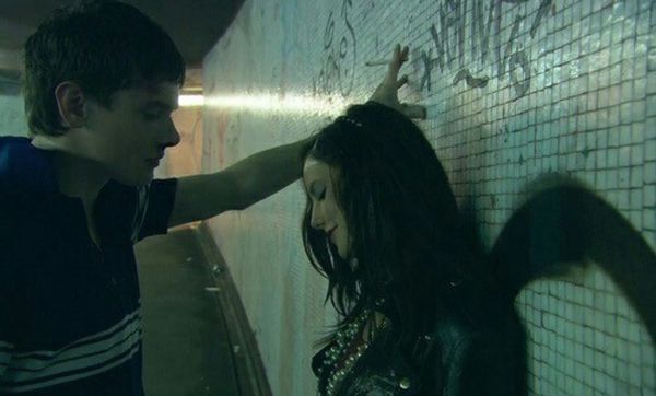 a man standing next to a woman near a wall