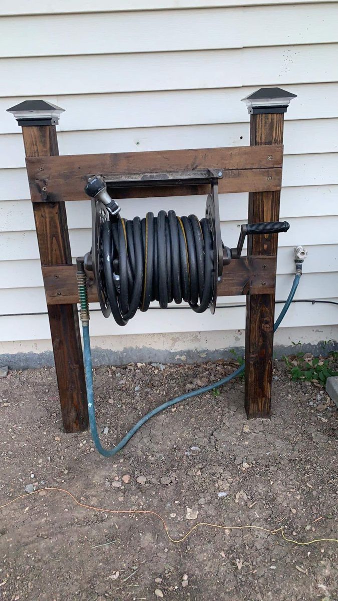 a hose is connected to the top of a wooden structure