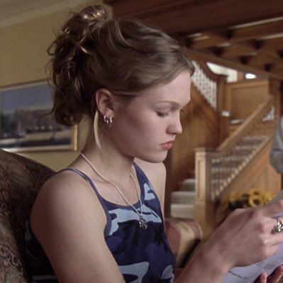 a woman sitting in a chair looking at her cell phone